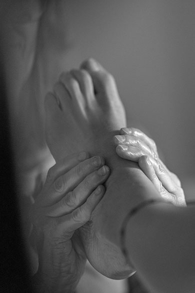 Primer plano de un pie masajeado por dos manos